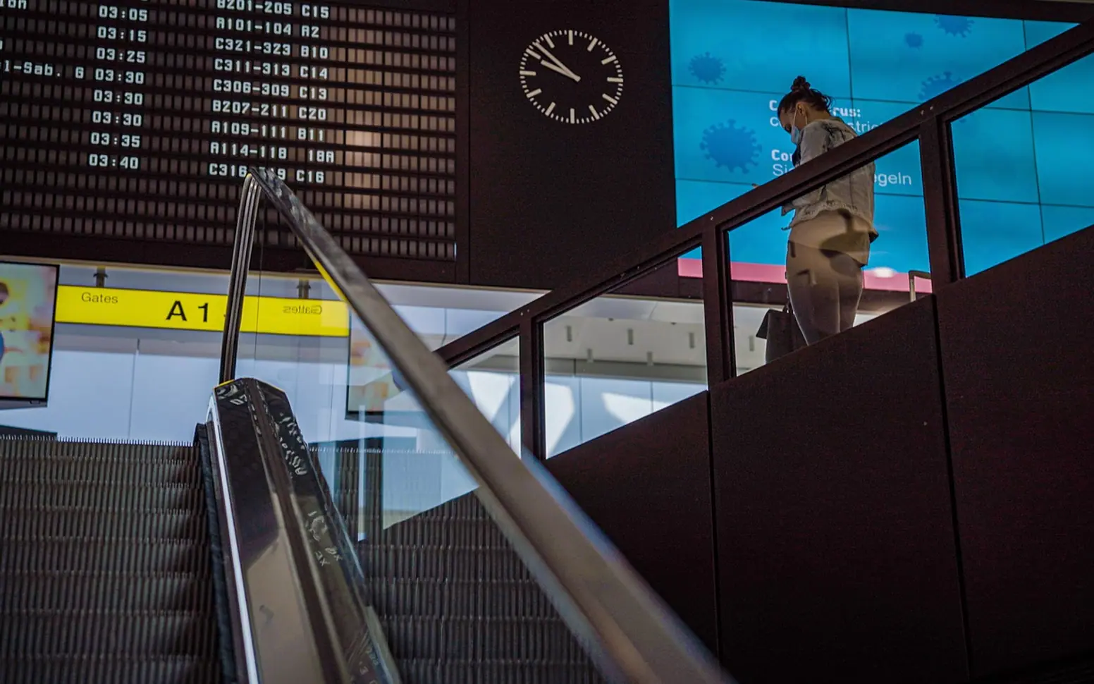Airport terminal, schedule board and escalator